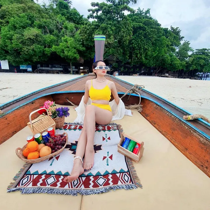 นักท่องเที่ยวนั่งพักบนหัวเรือหางยาว