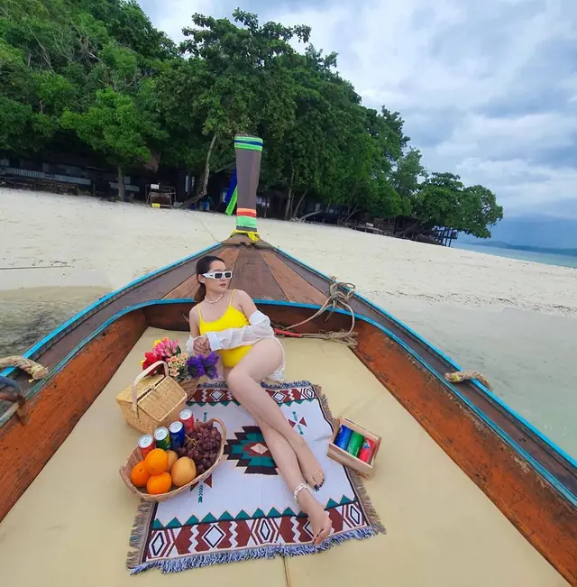 Traveller reclining on a luxury longtail bow moored at the beach
