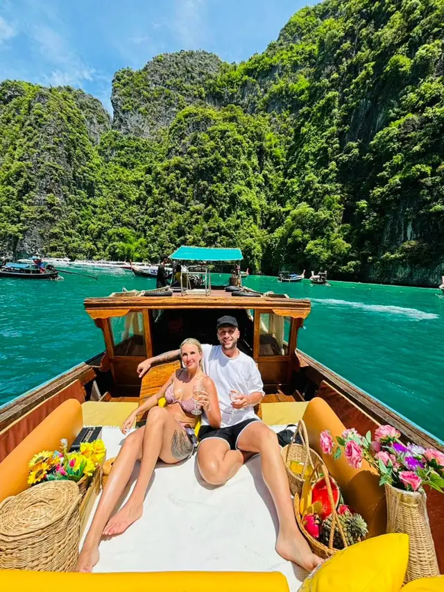 Couple on a luxury longtail bow surrounded by cliffs