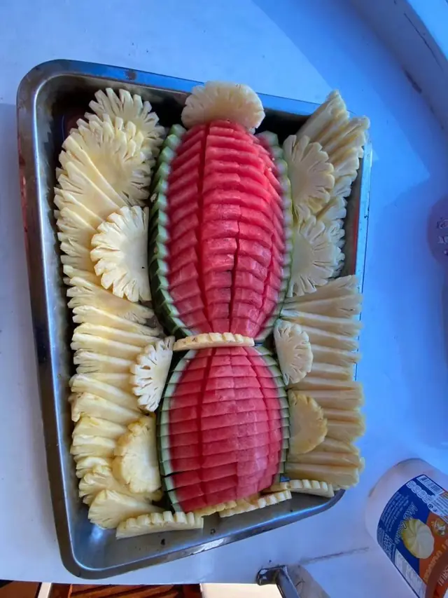 Carved watermelon and pineapple platter on board