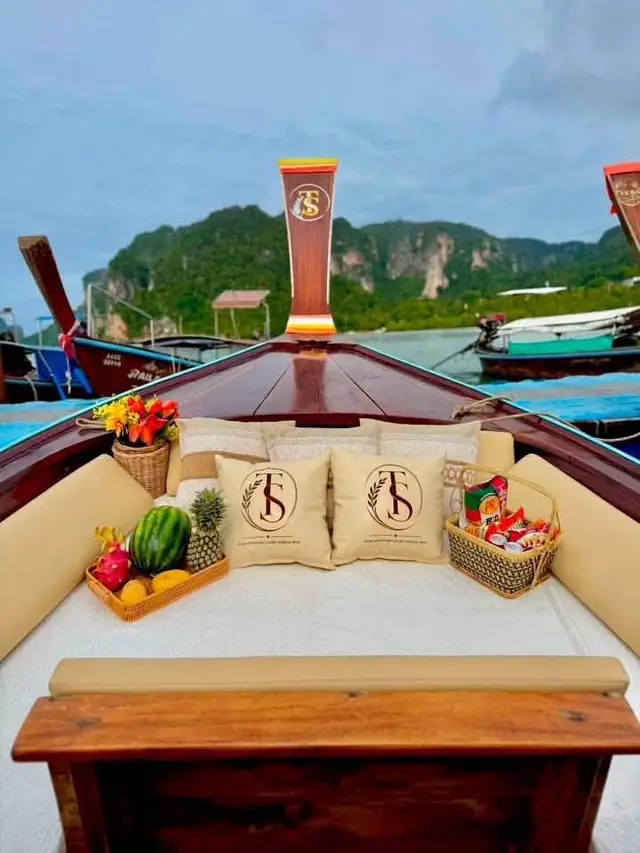 Luxury longtail bow with cushions and fruit, cliffs behind