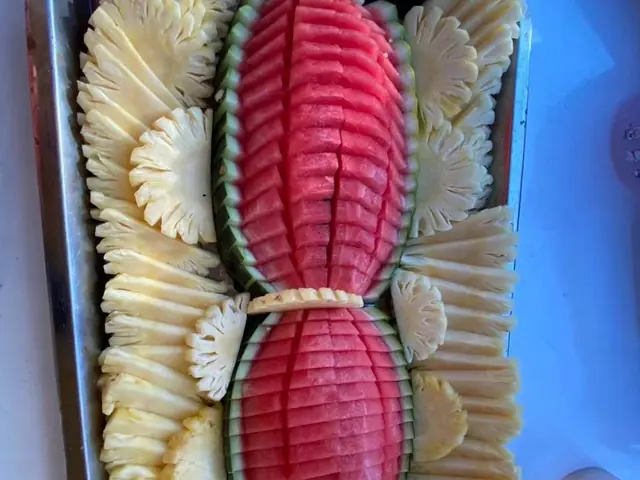 Carved watermelon and pineapple platter on board