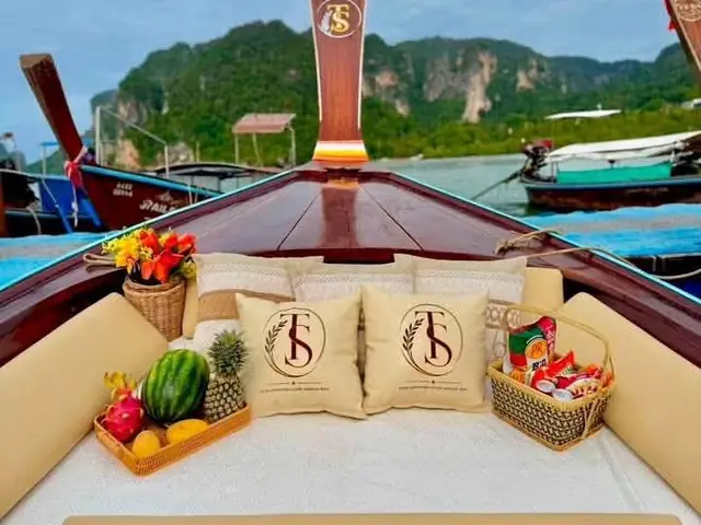 Luxury longtail bow with cushions and fruit, cliffs behind